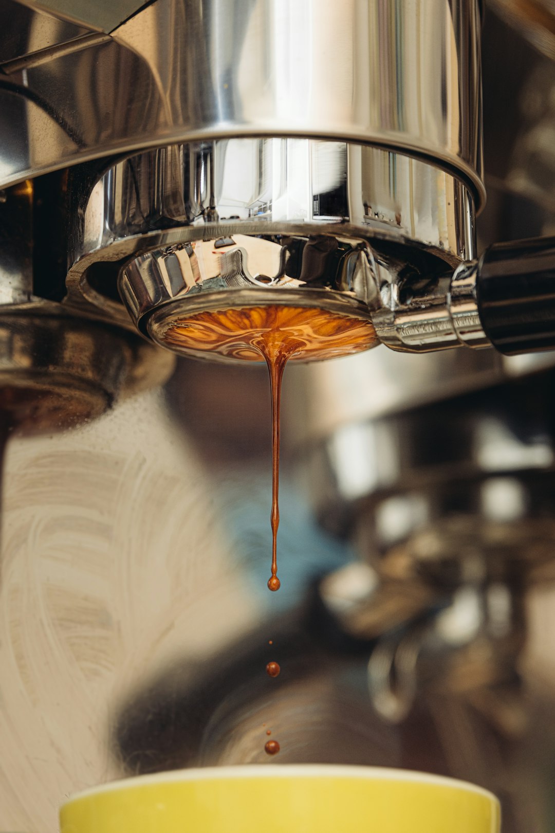 Espresso dripping from a bottomless naked portafilter during extraction